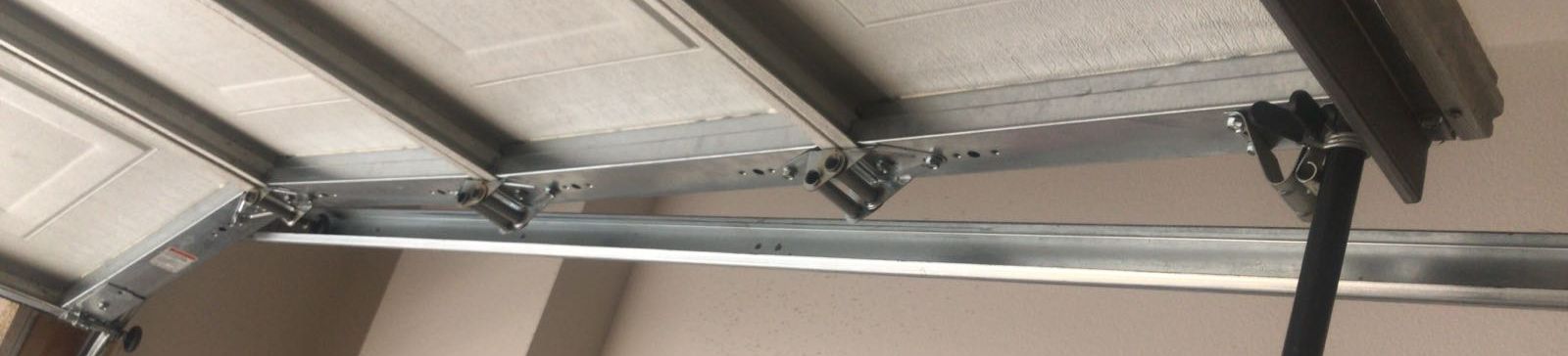 Close-up of a garage door roller being realigned and placed back on track in Champlin, MN