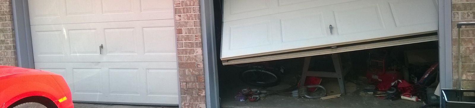 Dented garage door with misaligned panels awaiting professional panel replacement in Osseo, MN.