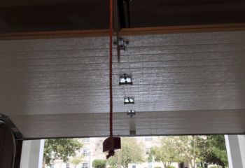 Interior view of newly installed overhead garage door with emergency release cord in Champlin, MN home.