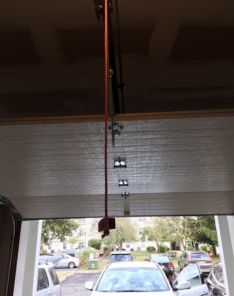Interior view of newly installed overhead garage door with emergency release cord in Champlin, MN home.