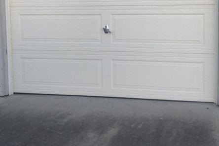 Exterior view of new white overhead garage door installed by Garage Door Repair Champlin.